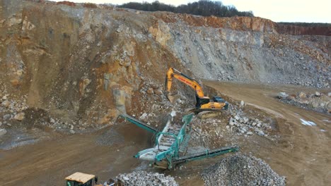 Maximizing-Material-Output:-An-Aerial-Shot-of-a-Tracked-Incline-Screener,-Excavator,-and-Wheel-Loader-in-a-Mining-Quarry