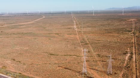 Aerial-drone-shot-of-power-lines-and-solar-wind-energy-farm-freeway-in-outback-with-sky-rugged-terrain-travel-tourism-Port-Augusta-Adelaide-South-Australia-4K