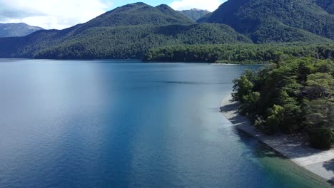 Erstaunliche-Aufnahme-Eines-Großen-Blauen-Sees-Mit-Bergen,-Die-Mit-Bäumen-Bedeckt-Sind,-In-Lago-Futalaufquen,-Patagonien,-Argentinien