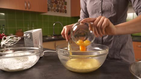 A-close-up-shot-of-a-young-woman-adding-yolk-into-a-honey-butter-mixture-and-using-an-electric-mixer-to-mix-them-together