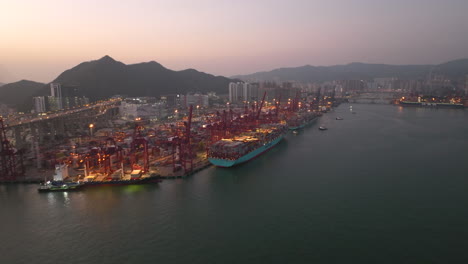 Multiple-container-vessels-moored-at-Modern-Terminals-in-Hong-Kong-whilte-traffic-drives-over-the-elevated-highway-in-the-background