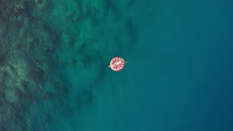 in-summer-the-girl-lies-on-the-colorful-seabed,-the-drone-shoots-upwards-Turkey