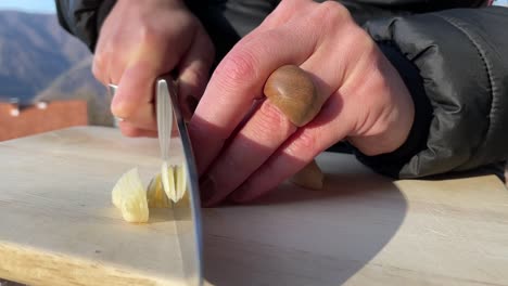 Chopping-garlic-on-a-wooden-board