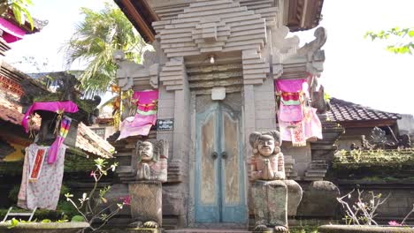 Balinese-Door-Entrance,-Traditional-Gate-in-Bali,-Indonesia,-Hindu-Statues,-Ornaments-and-Colorful-Fabrics-and-Styling-Umbrellas