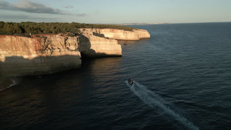 Amplio-Video-De-Drones-De-Un-Bote-Acercándose-A-Una-Cueva-En-La-Costa-Del-Algarve,-Portugal