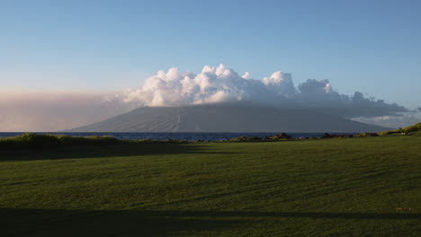Cloud-Capped-Mountain-From-Green-Coastal-Field-In-Wailea,-Maui,-Hawaii