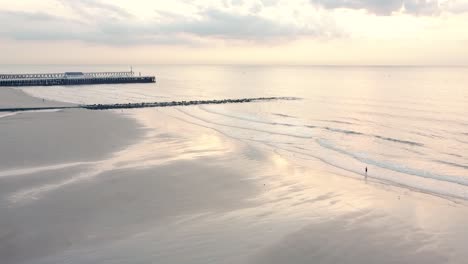 Schöner-Weißer-Strand-Mit-Spiegelndem-Meer-Im-Sonnenuntergang-Mit-Nüchternen-Farben,-In-Blankenberge,-Belgien