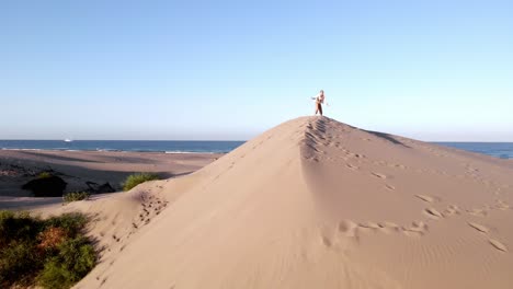 Frau-Tanzt-Auf-Sand,-Wüste-Trifft-Meer,-Luftaufnahme-Mit-Drohne