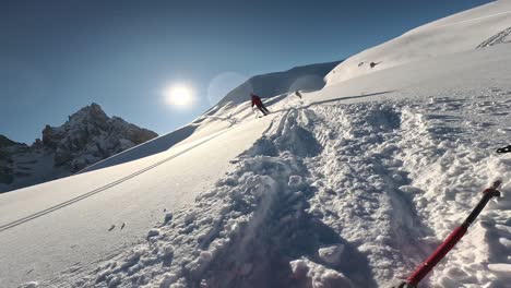 POV-Aufnahme-Eines-Skifahrers,-Der-Schneebedeckte-Berge-Hinunterfährt-Und-An-Einem-Sonnigen-Tag-Abstürzt