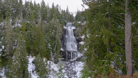 Pequeña-Cascada-En-El-Bosque-Cubierto-De-Nieve-Durante-El-Invierno