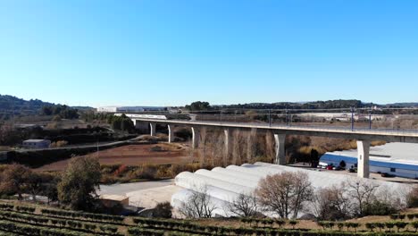 Aerial:-high-speed-train-crossing-a-viaduct-in-Spain,-between-Barcelona-and-Madrid