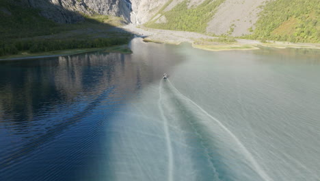 Boat-cuts-pattern-through-sediment-rich-glacier-water-of-fjord