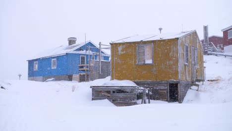 Slow-motion-video-of-yellow-and-blue-houses-in-a-snowstorm-in-Ilulissat,-Greenland