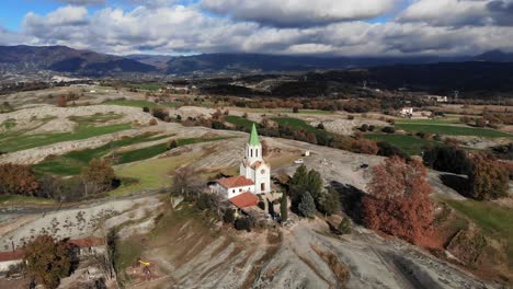 Aerial:-flying-towards-a-chappel-in-the-catalan-countryside-with-clouds-and-mountains-in-the-background