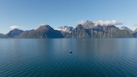 Malerische-Berge-Des-Lyngenfjords-Mit-Fischereifahrzeugen,-Die-Auf-Ruhiger-See-Fischen