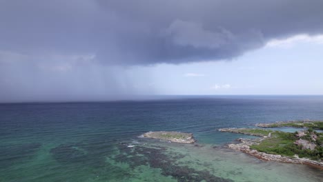 RAIN-IN-THE-CARIBBEAN-SEA-NEXT-TO-AN-ABANDONED-HOTEL-DRONE-SHOOT-TRACKING-SIDEWAYS