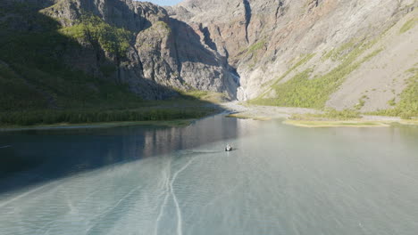 Cruiser-boat-navigating-on-sea-water-of-Lyngen-fjord-in-Scandinavian-Alps,-Norway