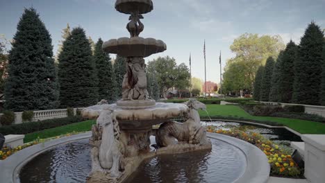 A-crane-stabilized-shot-of-a-beautiful-and-luxurious-stone-fountain-framed-by-exquisite-landscaping-and-rich-nature-tones