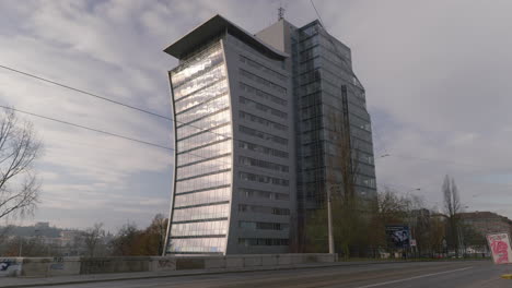 Einzigartig-Gebogenes-Luxus-Bürogebäude-Mit-Glasscheiben,-Das-Die-Sonne-Reflektiert