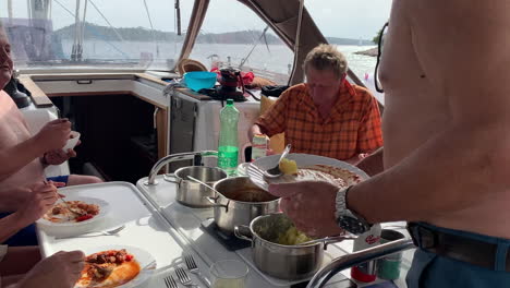 People-having-fun-inside-at-the-sailing-boat,-eating-and-drinking