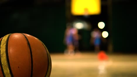 Basketball-Auf-Dem-Boden,-Während-Die-Spieler-Im-Hintergrund-Sind