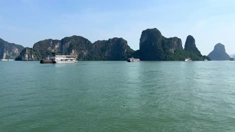 Sunny-day-on-Halong-Bay-with-junk-boats-surrounding-rock-formations