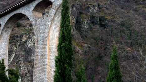 Aerial-push-in-shot-below-the-Pont-Séjourné-in-Fontpédrouse,-France-in-the-catalan-pyrenees