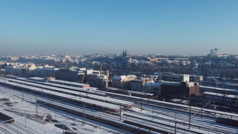 Prague-Smichov-Railway-Station-aerial-drone-winter-view,-Upper-castle-and-city-in-background,-Czech-Republic