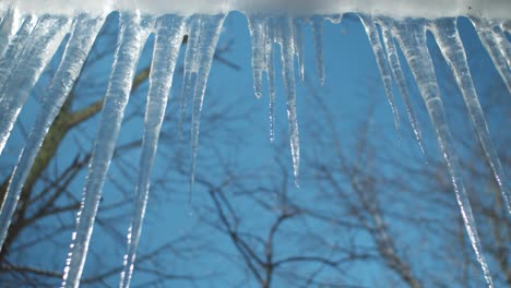 Ice-Stalactites-hanging-from-a-roof-ledge-with-water-dripping-from-it