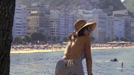 Fashionable-woman-watching-water-sports-off-the-beautiful-Copacabana-beach-in-Rio-de-Janeiro