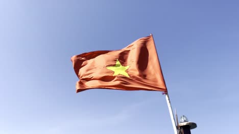 Bandera-Roja-Con-Estrella-Dorada-Ondeando-Al-Viento-Con-Cielo-Azul,-Vietnam