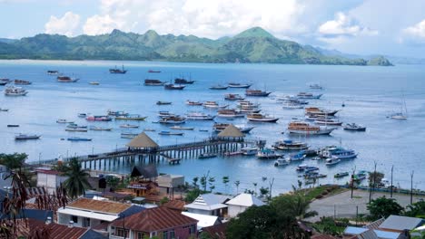 Panoramic-view-of-Labuan-Bajo-marina-and-docked-fishing,-liveaboard,-and-tour-boats-with-tropical-islands-in-the-distance-on-Flores-island,-Nusa-Tenggara-region-of-east-Indonesia