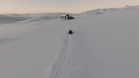 Einsames-Winterhaus-Mit-Schneebedecktem-Ozeanufer-Und-Bergblick,-Dolly-Nach-Vorne