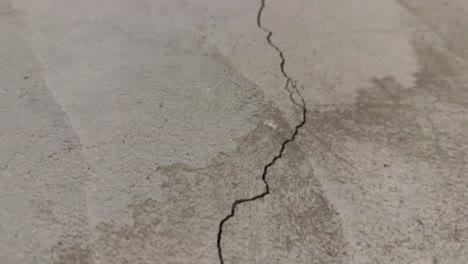 Close-up-of-one-long-crack-in-concrete-foundation-in-basement-from-settling-home