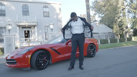 Groom-being-photographed-next-to-a-red-Corvette-on-his-wedding-day