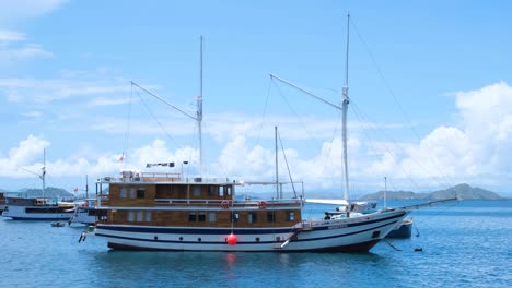 Beautiful-liveaboard-ship-boat-moored-in-idyllic,-calm-ocean-in-fishing-village-of-Labuan-Bajo,-Flores-island,-Nusa-Tenggara-region-of-east-Indonesia