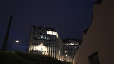 Neues-Büroparkgebäude-Neben-Einem-Schornstein-Am-Frühen-Morgen-Im-Dunkeln-Erschossen