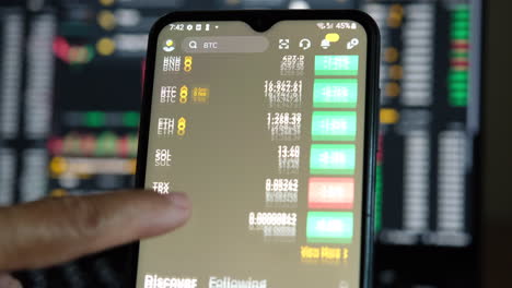 hand-scrolling-Binance-app-with-candle-sticks-in-the-background