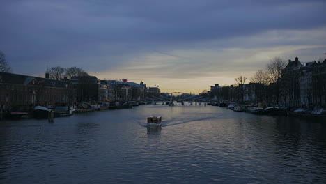 Amsterdam-Río-Amstel,-Puesta-De-Sol-En-Enero-De-2023,-Barco-Turístico-Pasando