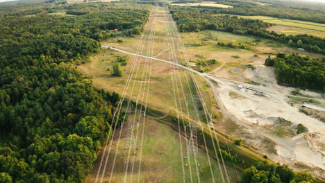 Vista-Aérea-De-Drones-De-Líneas-Eléctricas-De-Transmisión-De-Alto-Voltaje-Que-Pasan-A-Través-Del-Bosque-En-El-Campo-Rural
