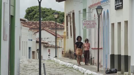 Dos-Personas-Caminando-Por-Una-Calle-De-Piedra-Del-Centro-De-La-Ciudad-Vieja-De-Goiás,-Brasil