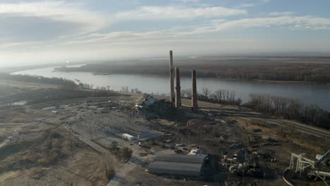 Drone-shot-panning-around-smoke-stacks-next-to-the-Mississippi-with-a-demolished-coal-power-plant
