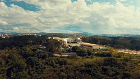 Building-of-university-situated-on-top-of-a-mountain-surrounded-by-lush-trees-in-a-vast-forest