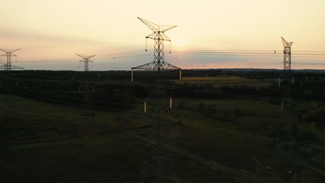 Aerial-Drone-Flyover-of-High-Voltage-Transmission-Power-Lines-Silhouette-in-Rural-Countryside