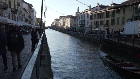 People-walk-along-the-shore-of-the-Naviglio-Milanese-canal-and-relax-in-the-pubs,Slow-motion-30fps,-Milan,Italy