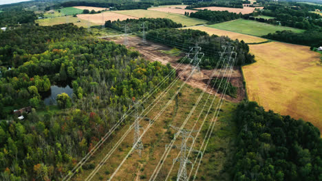Aerial-Drone-Flyover-of-High-Voltage-Transmission-Power-Lines-Passing-through-Forest-in-Rural-Countryside