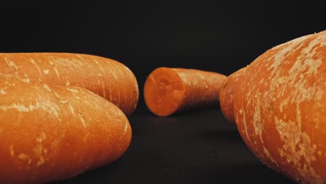 Close-Up-Dolly-In-Slider-Shot-Of-Fresh-Organic-Orange-Carrots-Isolated-On-Dark-Background