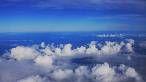 Una-Hermosa-Escena-De-Las-Nubes-Y-El-Océano-Visto-Desde-La-Ventana-De-Un-Avión-A-La-Luz-Del-Día