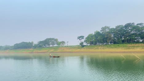 Barco-De-Pesca-En-Medio-De-Un-Río-Pacífico,-Sylhet,-Bangladesh,-Pescador-A-Bordo
