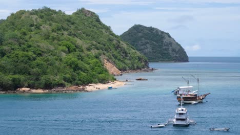Idyllic-tropical-islands-with-white-sandy-beaches-and-boats-moored-on-beautiful-calm,-blue-ocean-in-Labuan-Bajo-on-Flores-island,-Nusa-Tenggara-region-of-east-Indonesia